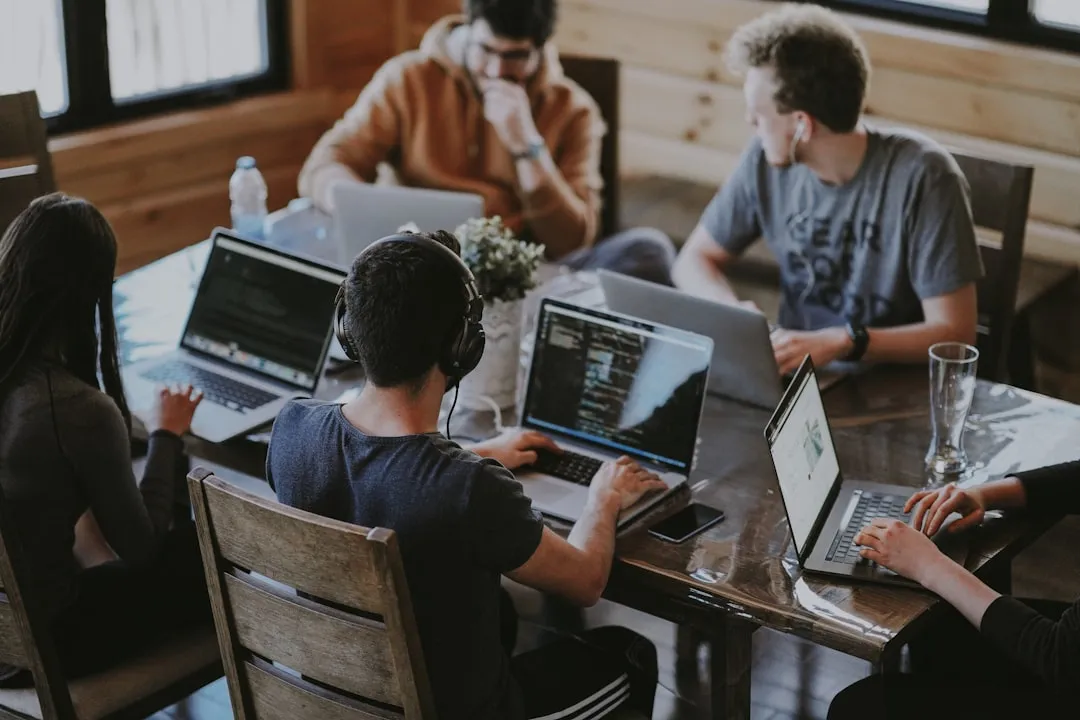 Team arbeitet an Laptops als Symbol fuer Softwaremodernisierung von Altsystemen